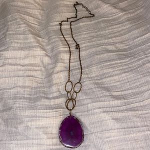 Long gold tone necklace with large glass geode style charm